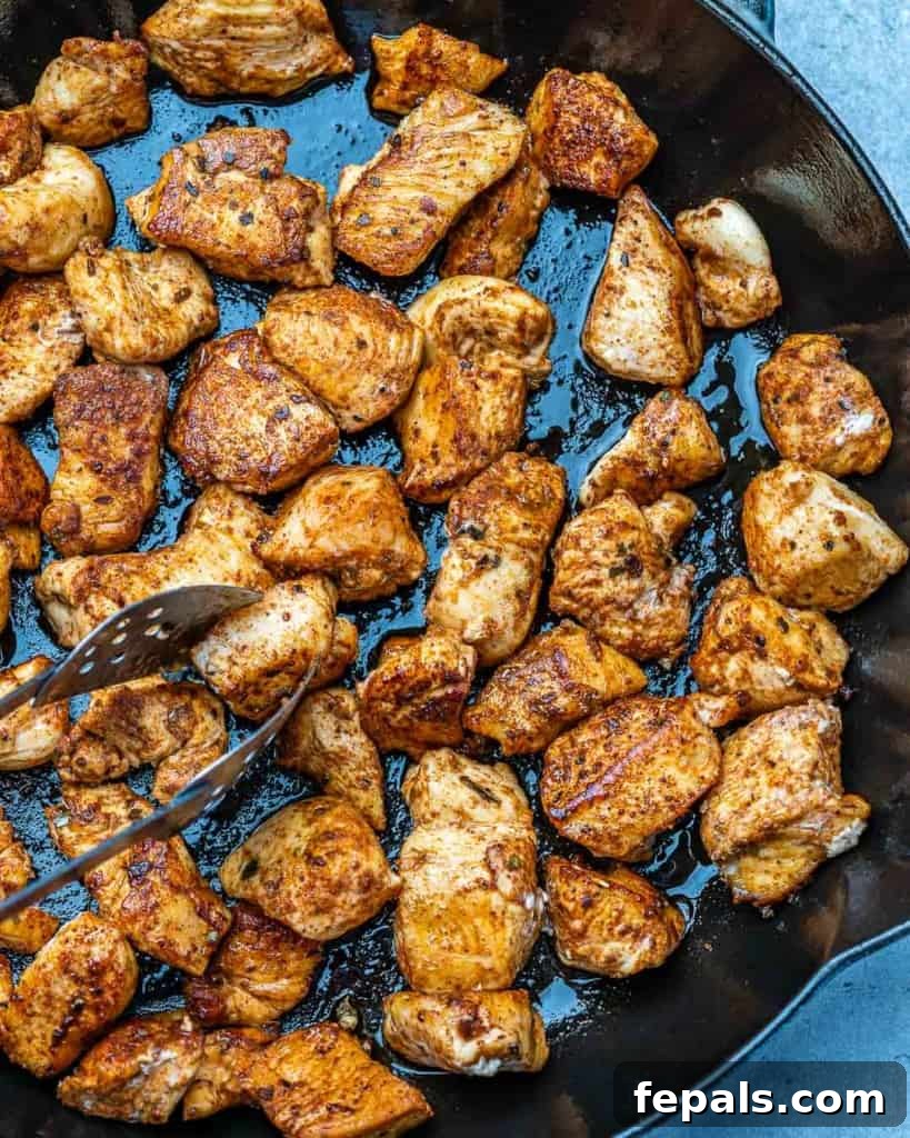 Sautéed cilantro lime chicken bites sizzling in a hot skillet, becoming golden and cooked through