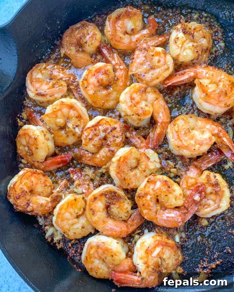 Golden Honey Mustard Shrimp and Crispy Potatoes 3 cooked honey shrimp in black skillet