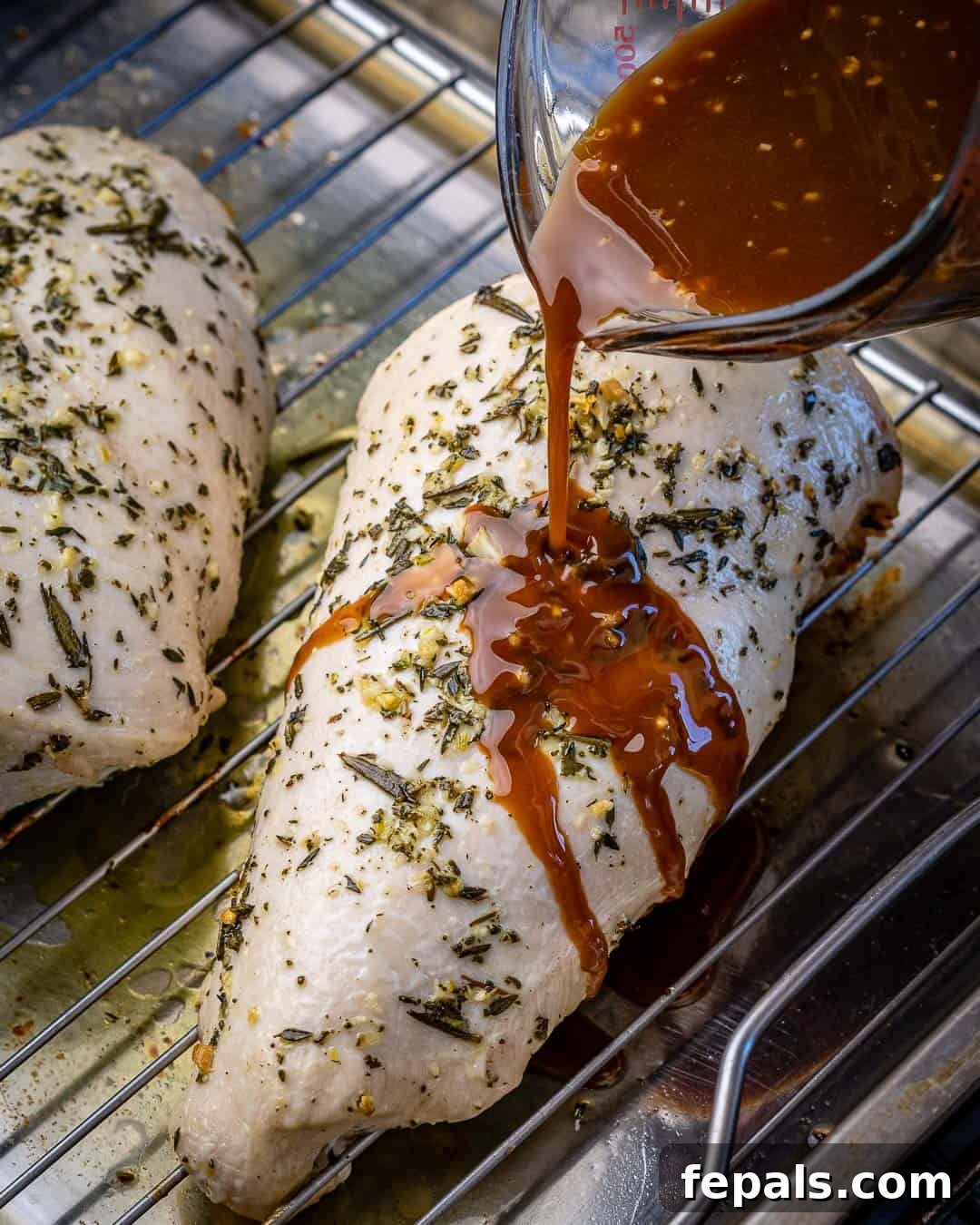 Pouring maple mustard glaze on partially cooked turkey breast