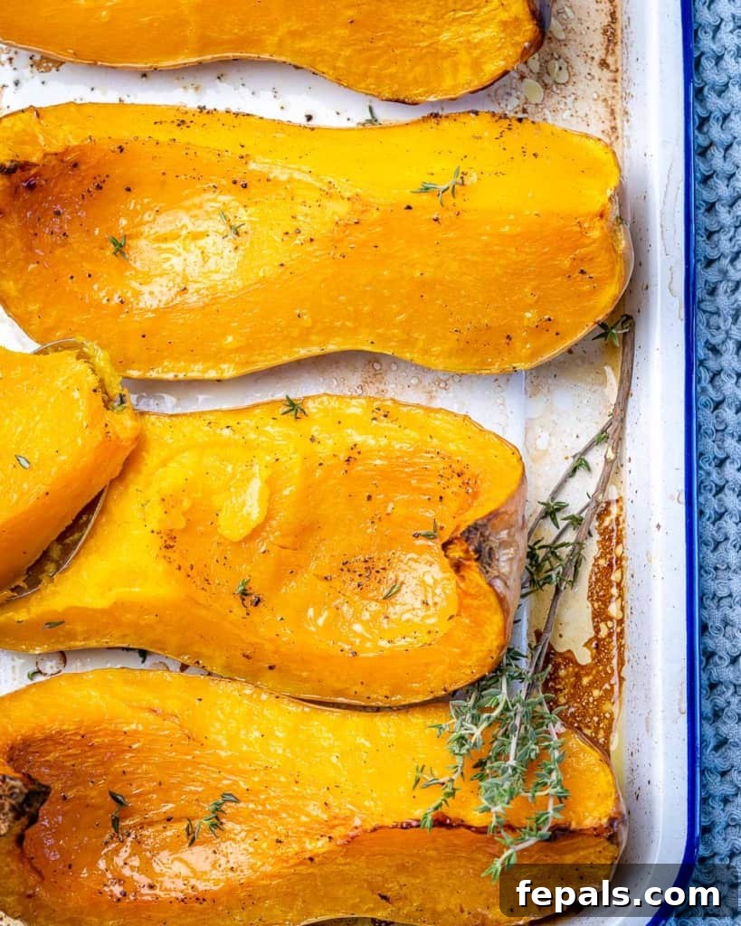 Golden Roasted Butternut 11 Overhead view of several roasted butternut squash quarters arranged on a baking pan, ready to serve.
