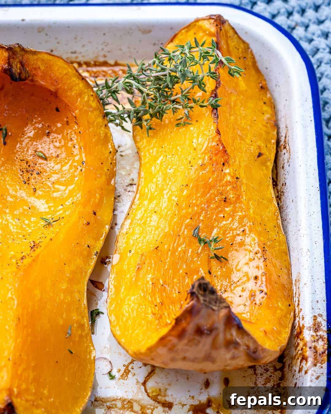 Golden Roasted Butternut 7 A wedge of roasted butternut squash garnished with fresh herbs, showcasing its golden color.