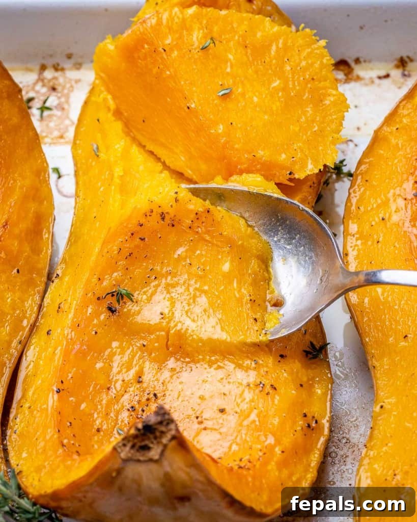 Golden Roasted Butternut 10 Close-up view of a spoon gently scooping the soft, cooked flesh of roasted butternut squash.
