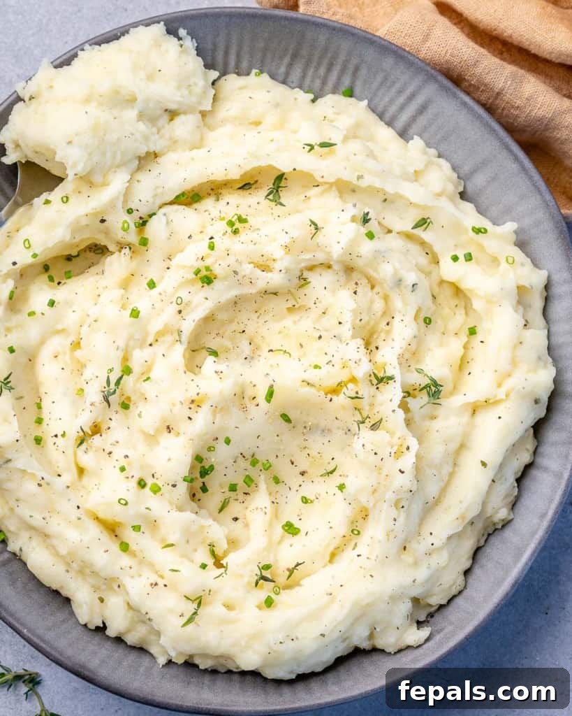 Top view of fluffy mashed potatoes on a gray plate, ready to be served.