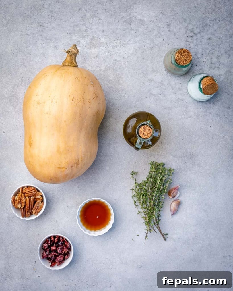 Maple Caramelized Butternut 4 Layout of fresh ingredients for maple roasted butternut squash, including a whole squash, olive oil, maple syrup, garlic, salt, pepper, and fresh thyme.