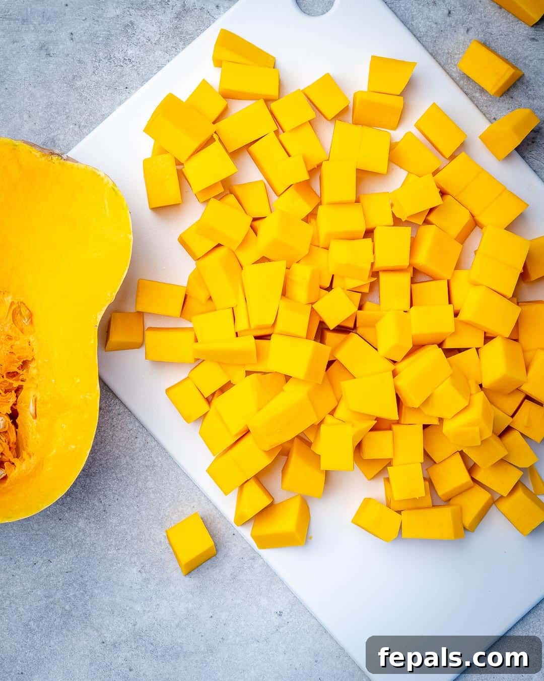 Maple Caramelized Butternut 5 Butternut squash chopped into uniform cubes on a cutting board, ready for seasoning.