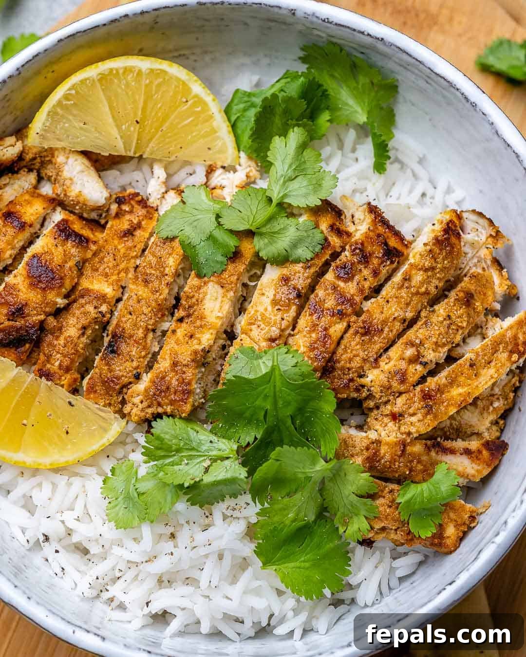 Flavorful Tandoori Chicken Made Easy 8 Sliced tandoori chicken breast served over rice with cilantro garnish