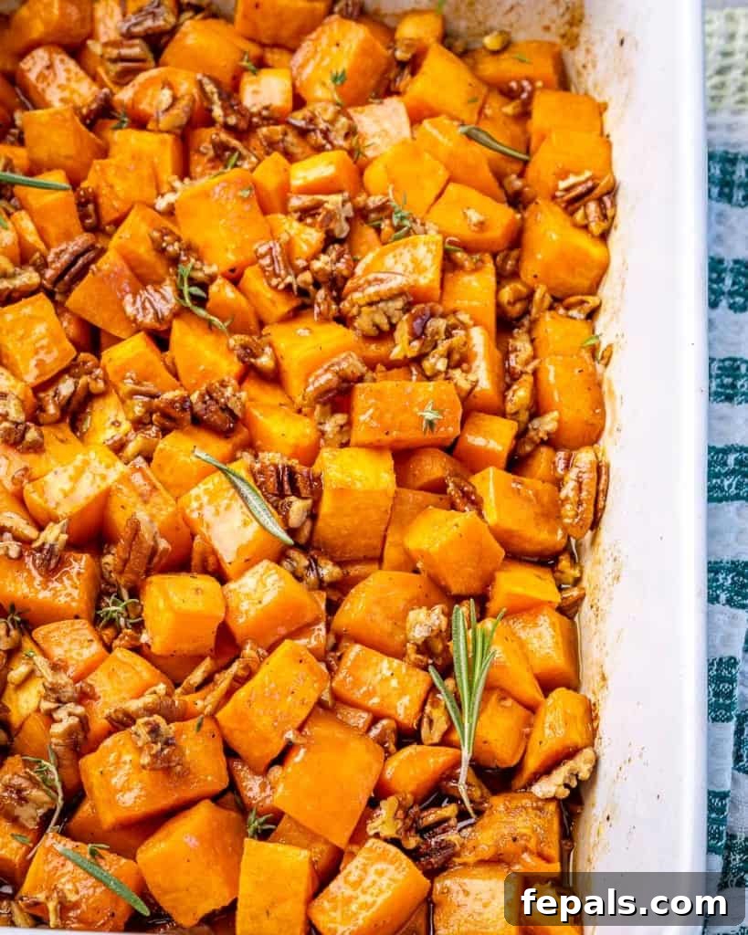 A white dish of roasted sweet potatoes on a cloth. 