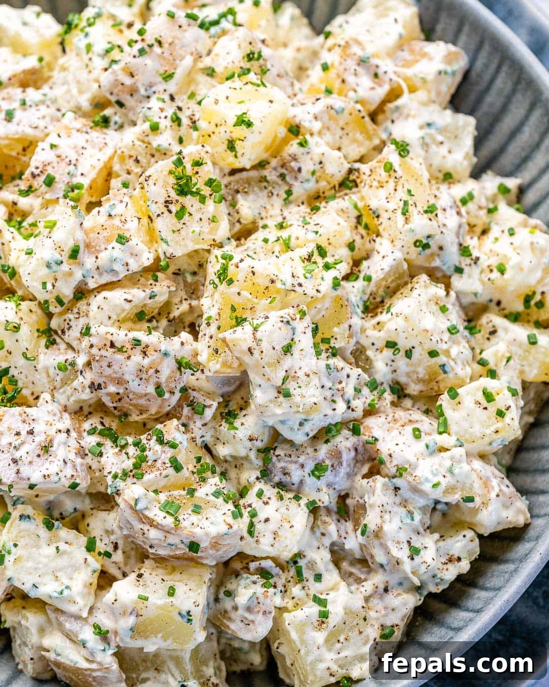 Simple Zesty Mustard Potato Salad 7 A close-up view of the finished Healthy Mustard Potato Salad served in an elegant gray bowl, highlighting its creamy texture and fresh herbs.
