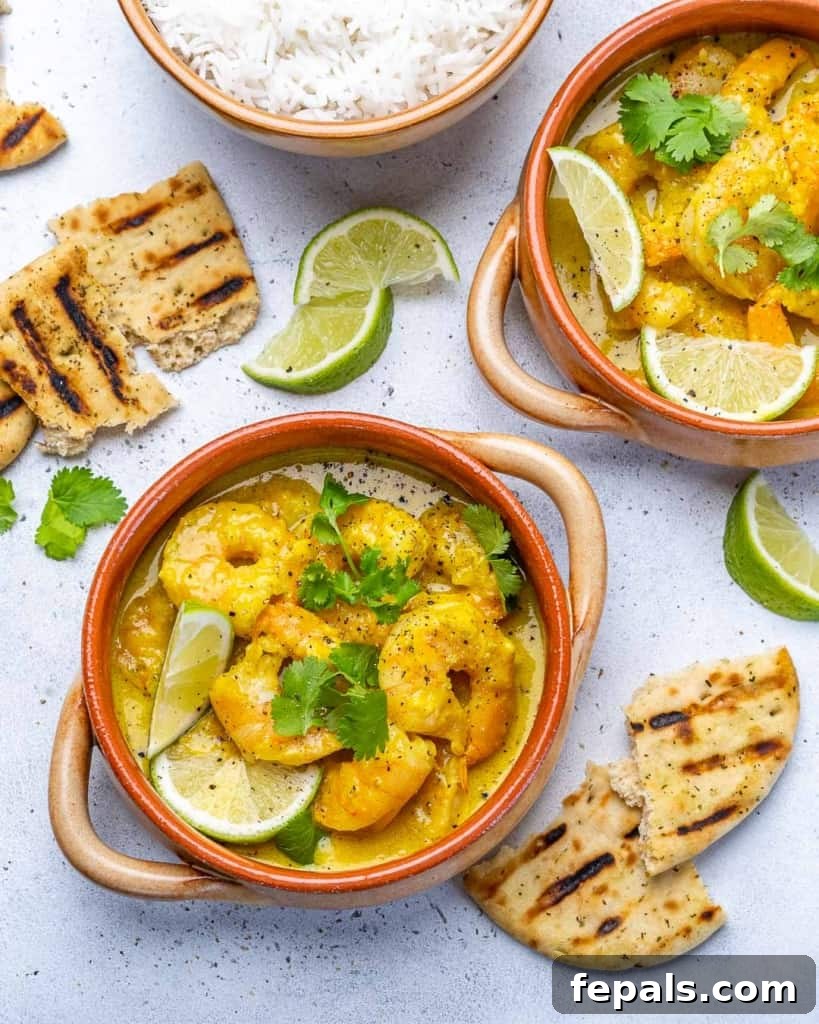Creamy Coconut Green Curry with Shrimp 7 top view of two bowls of shrimp curry with lemon and cilantro garnishes