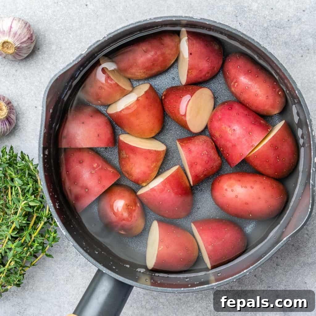 red potatoes halved in water to be par boiled