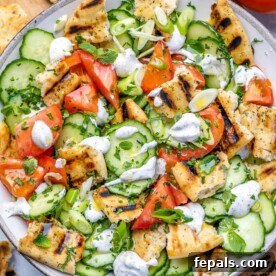 Vibrant Mediterranean Chopped Salad 12 top view chopped salad with naan bread and creamy dressing on a white plate