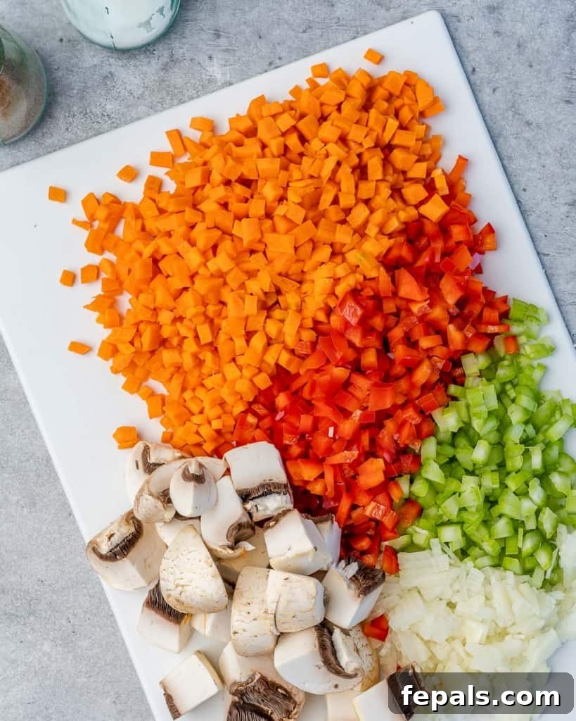 Silky Chicken Mushroom Bliss 5 chopped veggies on a white cutting board