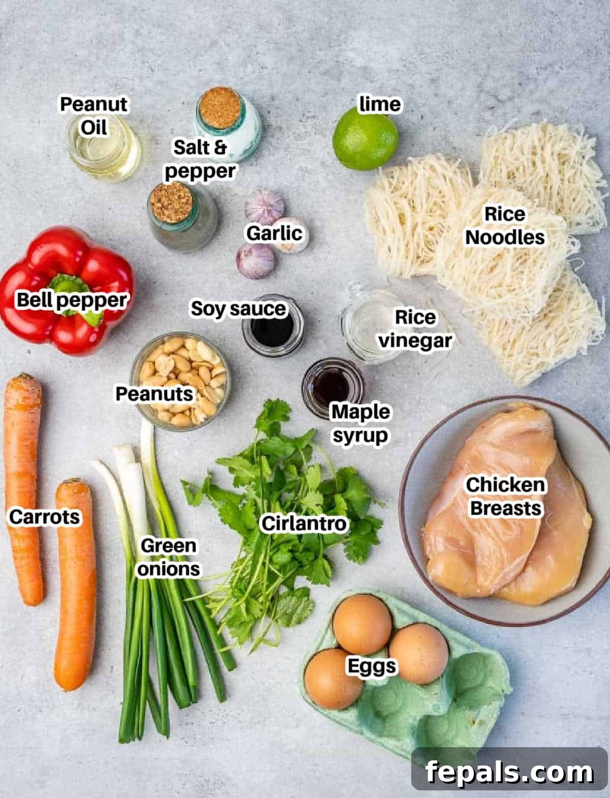 Signature Chicken Pad Thai 3 A selection of fresh ingredients laid out, including Thai rice noodles, chicken breast, bell pepper, carrots, garlic, green onions, eggs, peanuts, cilantro, and sauce components, ready to make chicken pad thai.