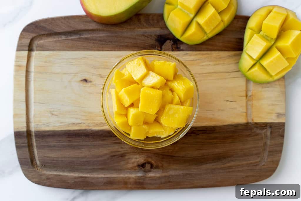 Top view of neatly chopped mango cubes in a glass bowl, ready to be enjoyed