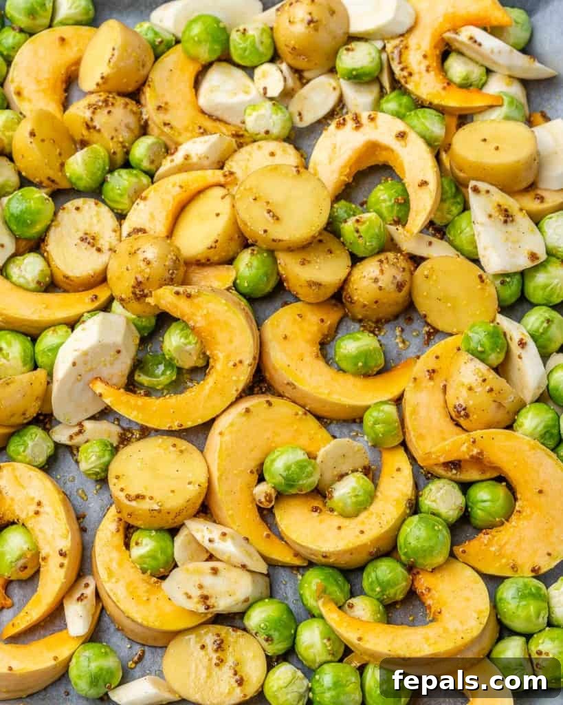 Golden Roasted Vegetables 6 Chopped vegetables, seasoned with a vibrant mustard sauce, spread evenly on a parchment-lined baking sheet, ready for the oven.