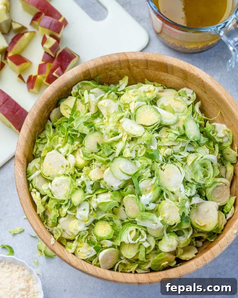 Elevated Shaved Brussels Salad 5 Close-up photo of finely shaved Brussels sprouts collected in a large mixing bowl.