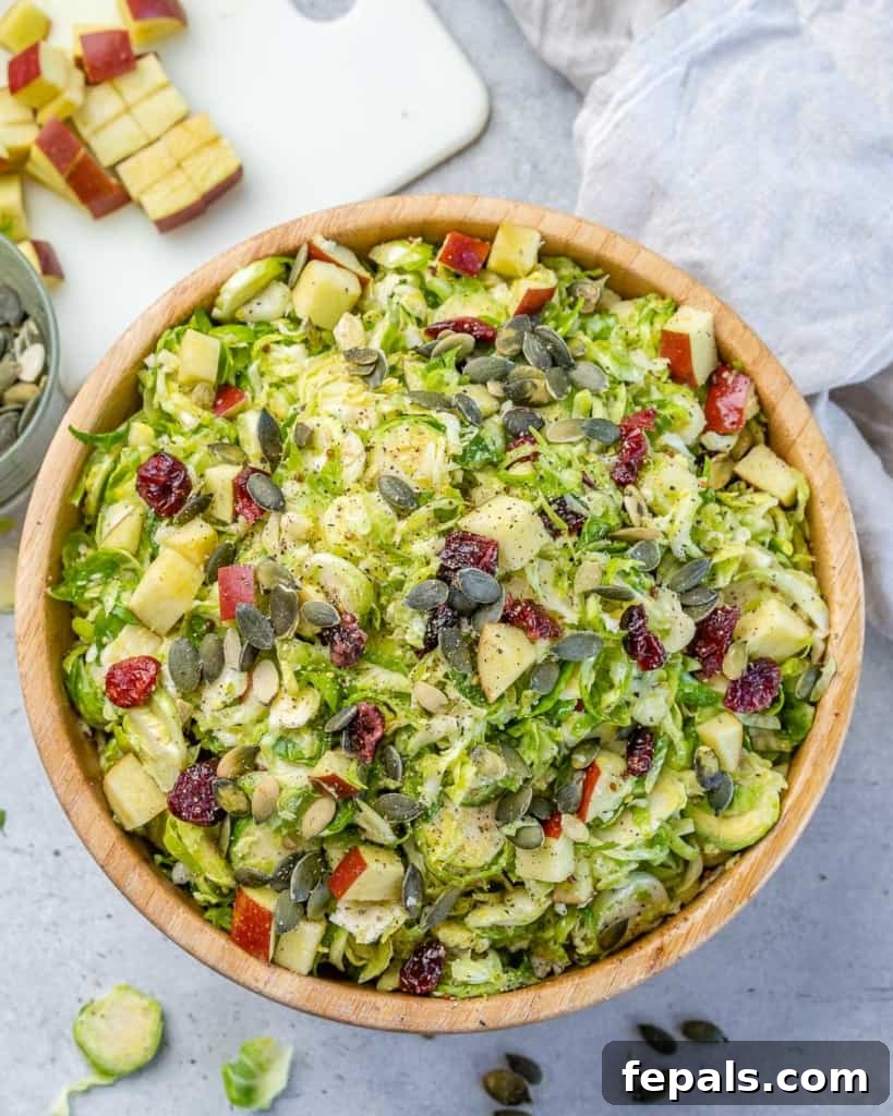 Elevated Shaved Brussels Salad 9 Overhead photo of a large bowl filled with a vibrant Brussels sprouts salad, garnished beautifully.