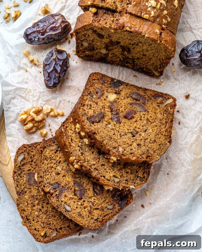 Top view of slices of freshly baked banana date nut bread, garnished with extra walnuts and dates.