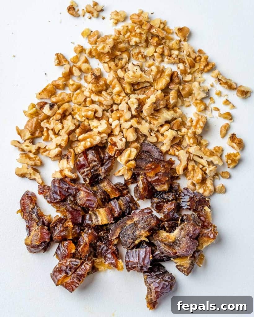 Chopped walnuts and dates neatly arranged on a wooden cutting board.