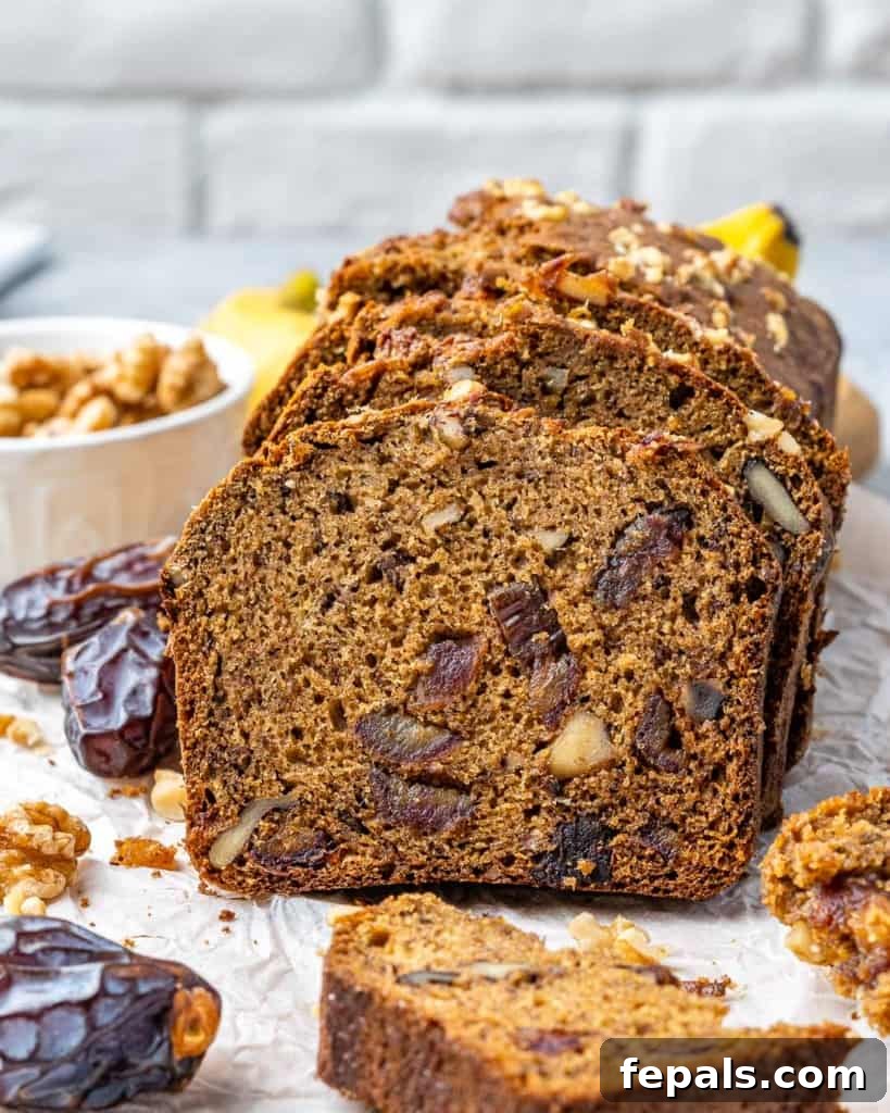 A side shot of a perfectly baked and sliced banana date nut bread.