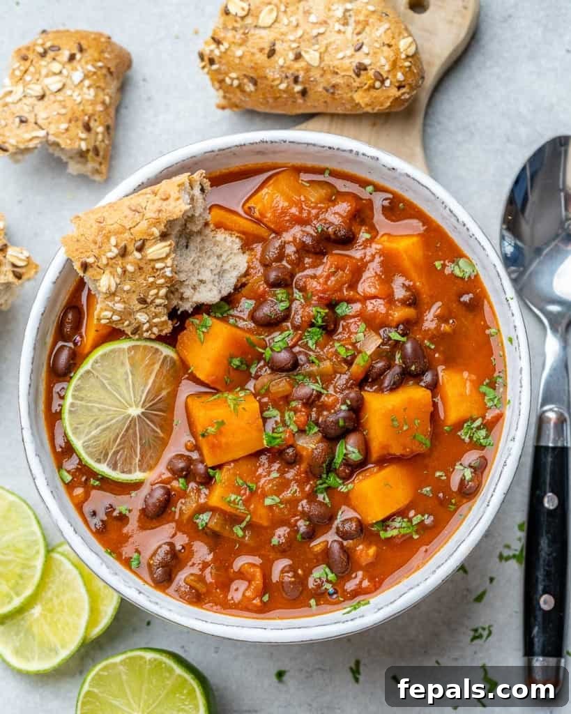 Comforting Sweet Potato Chili 3 An inviting top-down shot of sweet potato chili served in a white bowl, perfectly garnished with fresh cilantro.