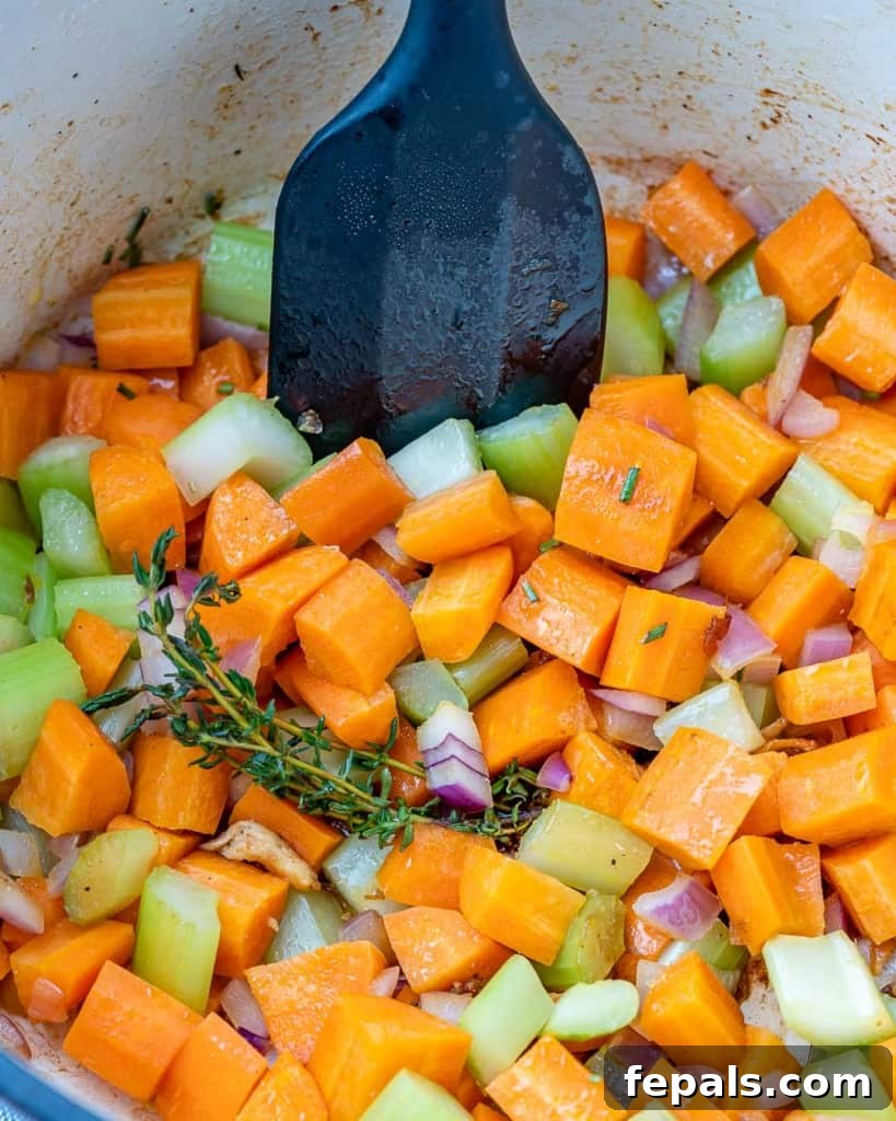 Colorful assortment of vegetables being added into a large cooking pot.