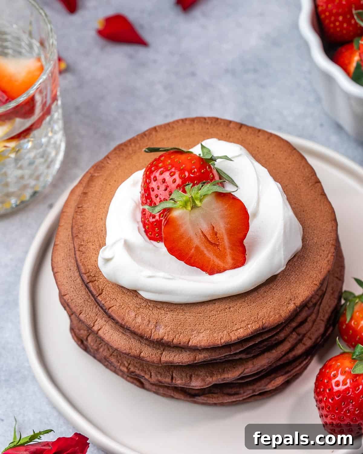 Top view of red velvet pancakes topping with cream cheese and strawberries. 