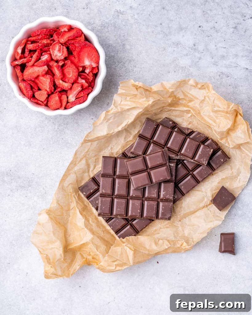 Nourishing Chocolate Bark 4 2 ingredients on a board, dark chocolate and dried strawberries