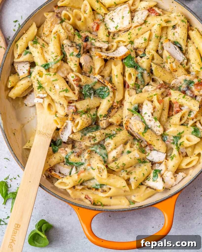 Creamy Chicken Spinach Pasta 7 Pasta with chicken and spinach in orange skillet
