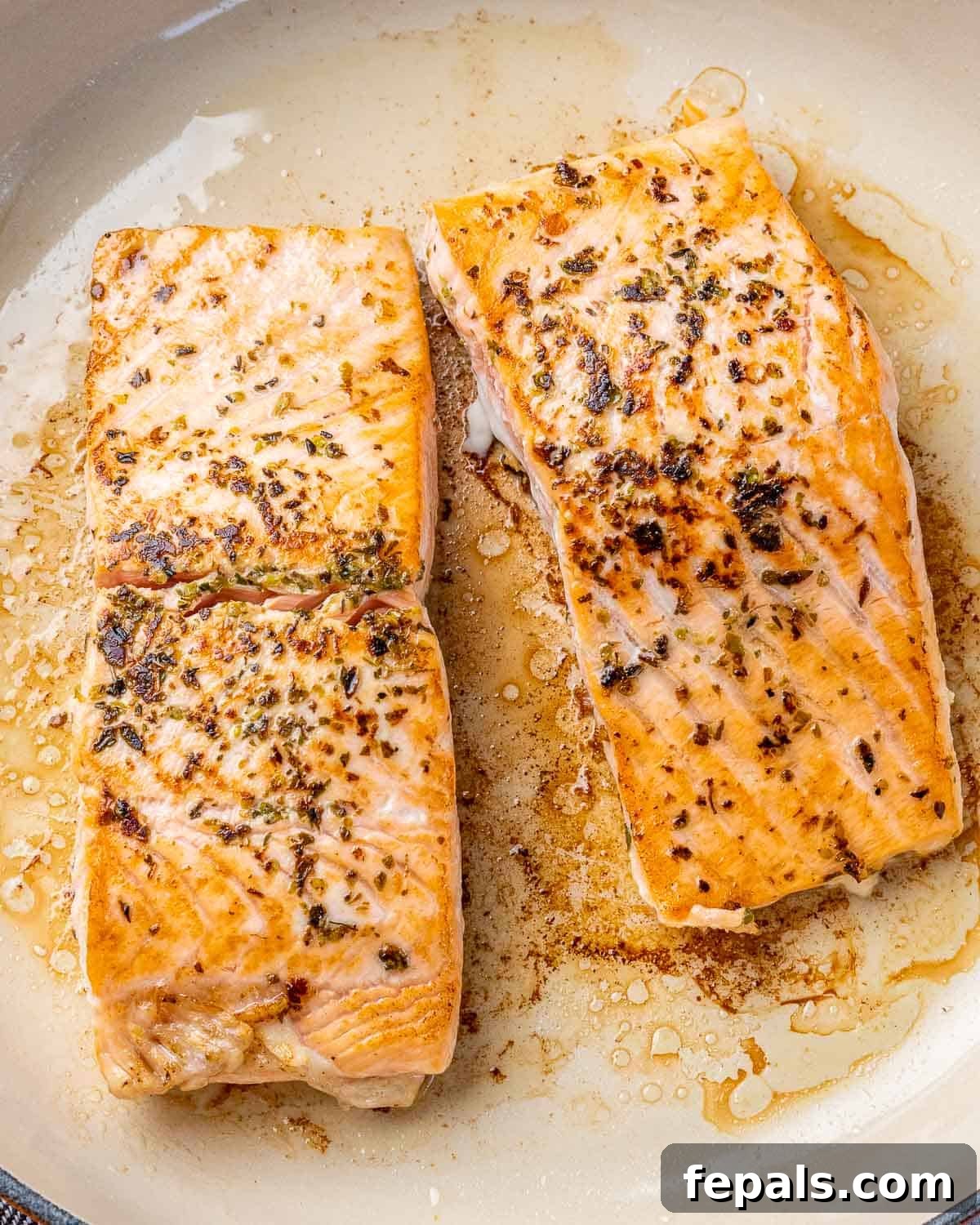 Zesty Salmon Piccata 6 Two salmon fillets searing to a perfect golden brown in a hot non-stick skillet, creating a delicious crust.