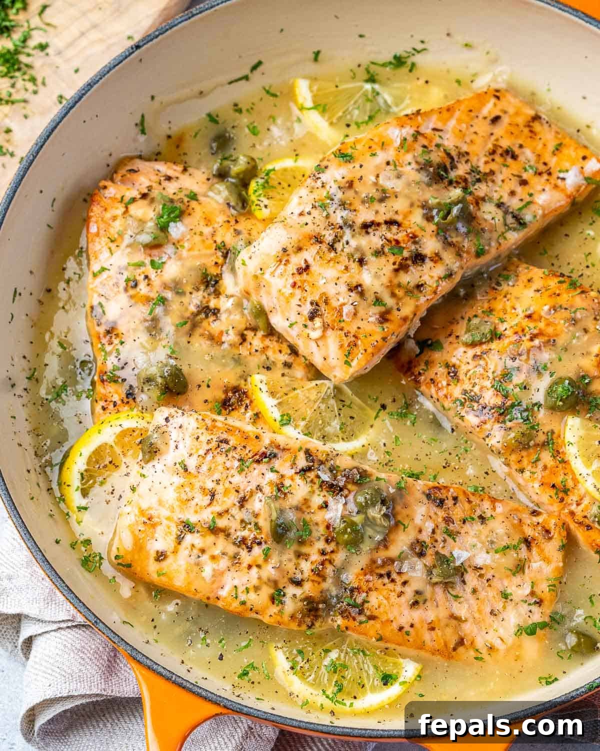 Zesty Salmon Piccata 7 A large skillet filled with cooked Salmon Piccata, beautifully garnished with fresh parsley and ready to be served.
