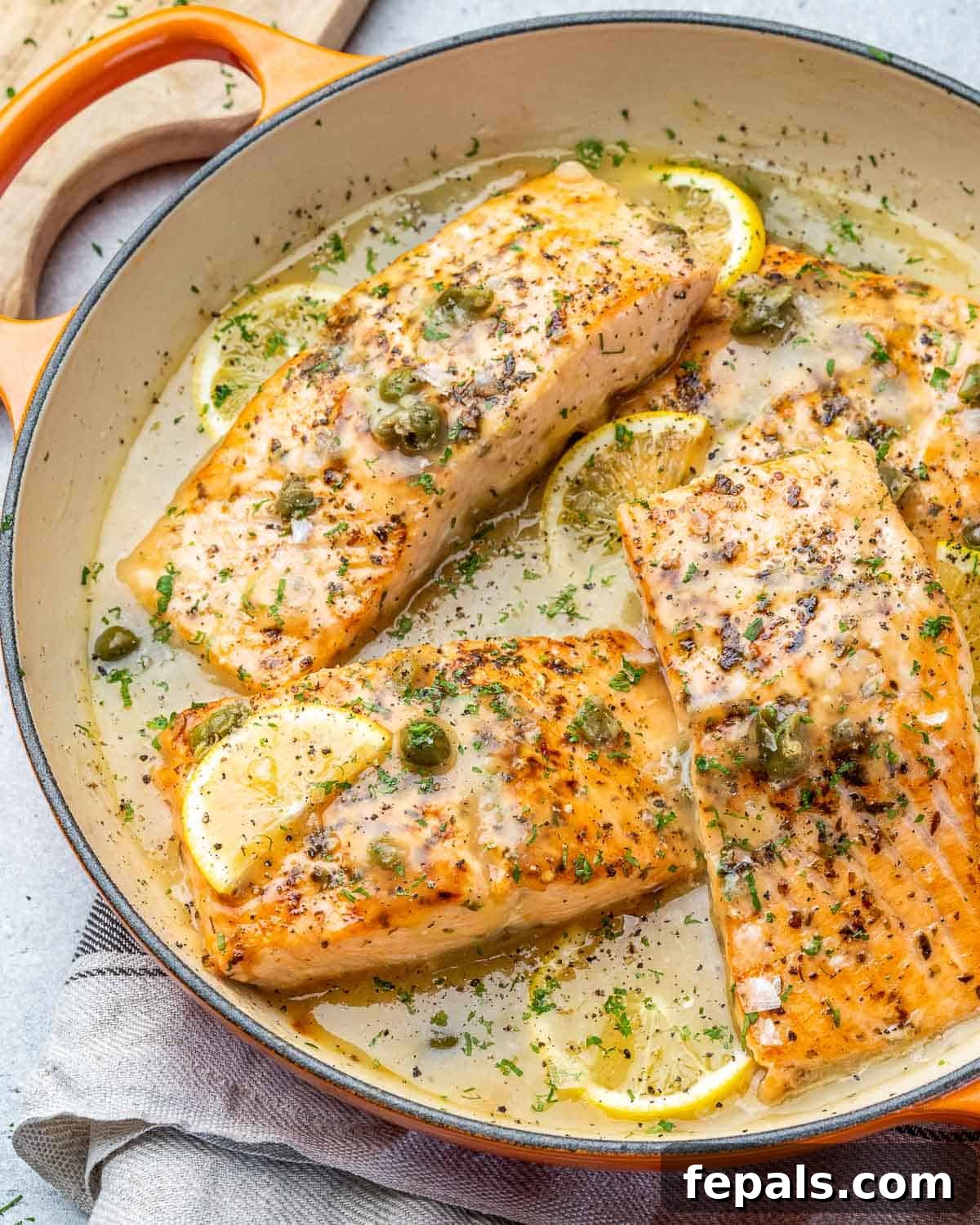 Zesty Salmon Piccata 8 A side view of the skillet showcasing perfectly cooked Salmon Piccata with its vibrant lemon caper sauce, ready to be served.