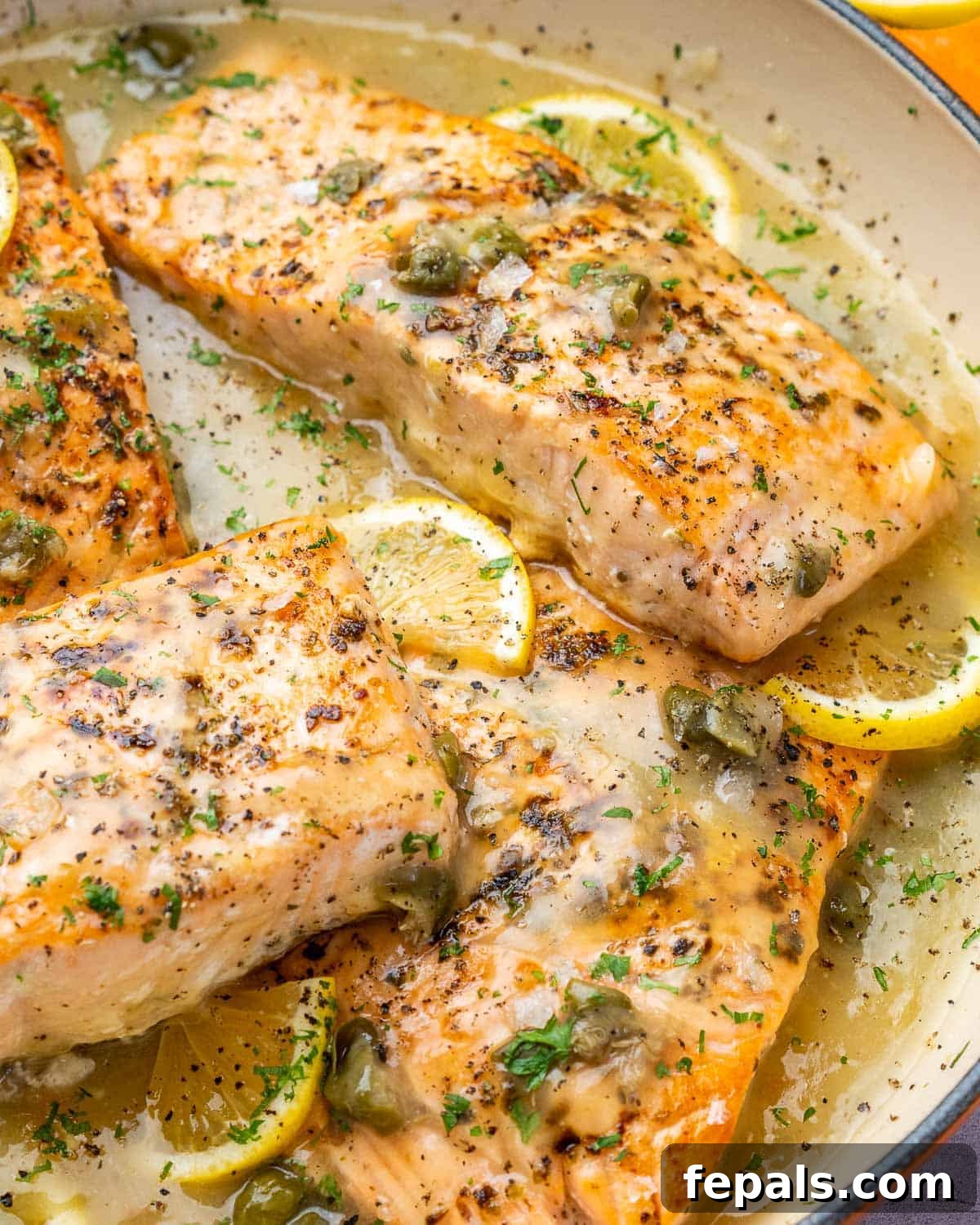 Zesty Salmon Piccata 9 Close-up view of four salmon fillets generously smothered in the rich, creamy lemon caper sauce, garnished with fresh herbs.