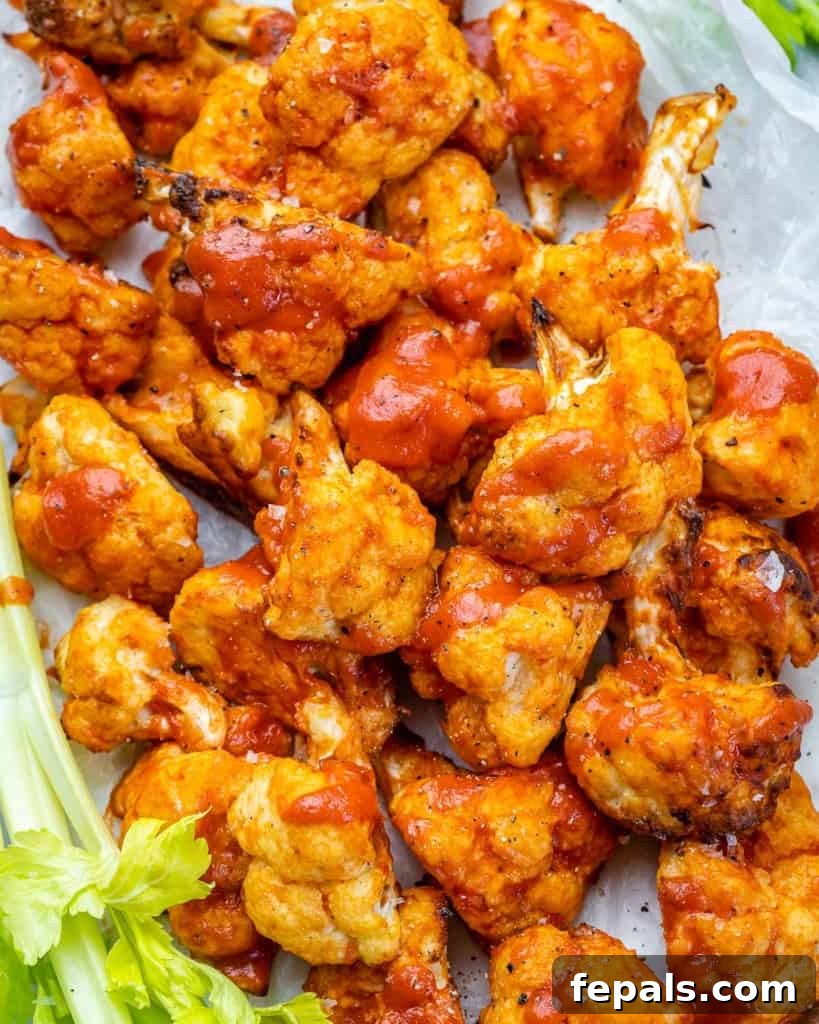 Top view of a beautifully arranged white dish filled with golden-brown buffalo cauliflower bites, ready to be enjoyed.