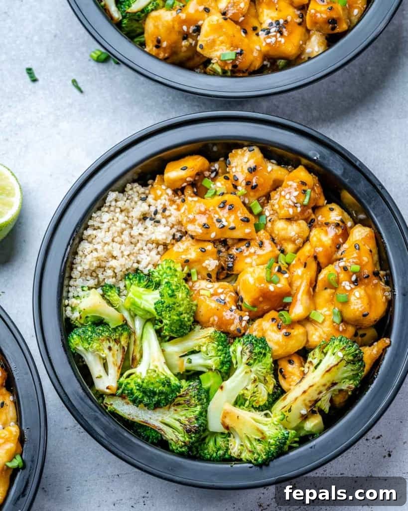 Top view of a colorful meal prep bowl featuring honey garlic chicken, vibrant broccoli, and fluffy quinoa.