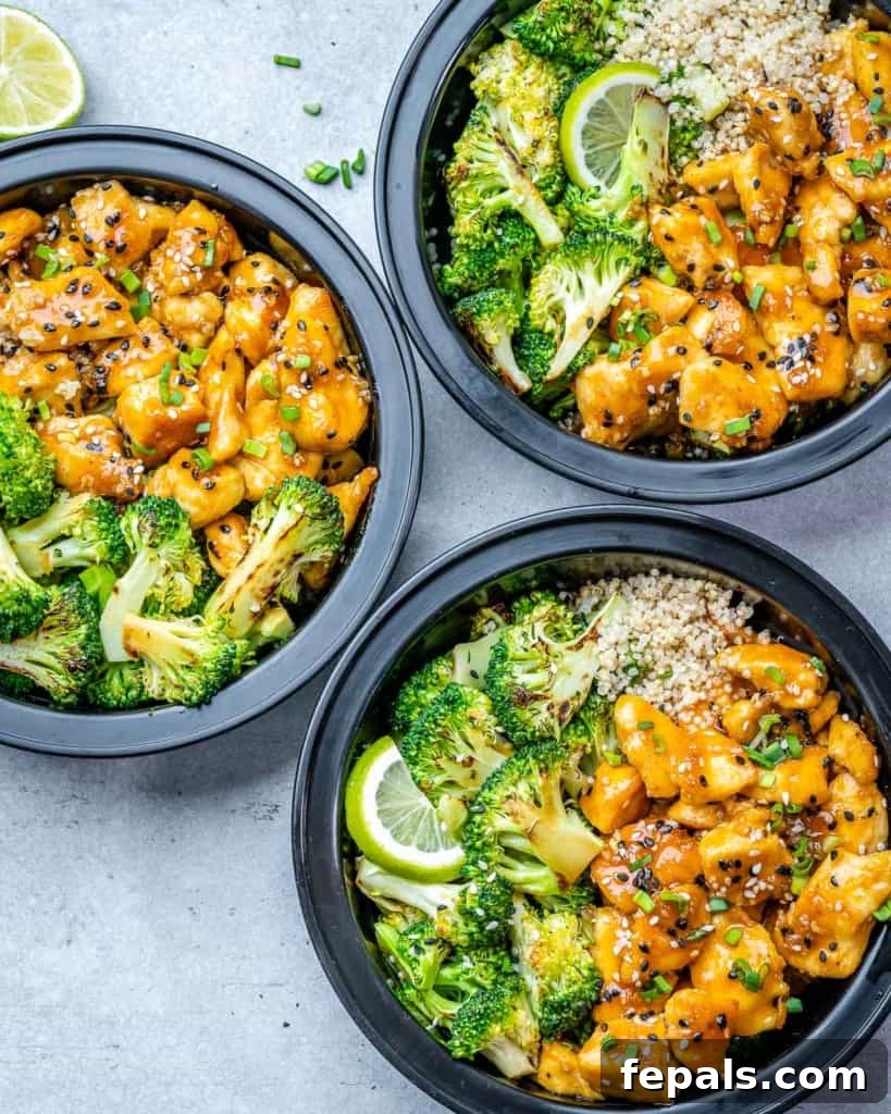 Finished meal prep bowls with honey garlic chicken, broccoli, and quinoa, ready for refrigeration.