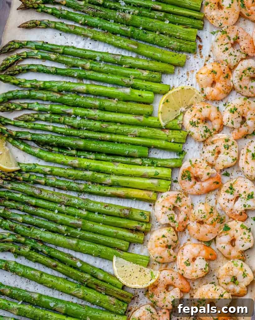 Roasted Garlic Shrimp & Asparagus Sheet Pan Dinner 6 Baked garlic shrimp and asparagus are beautifully laid out on a sheet pan, ready to be served, with a hint of fresh herbs.
