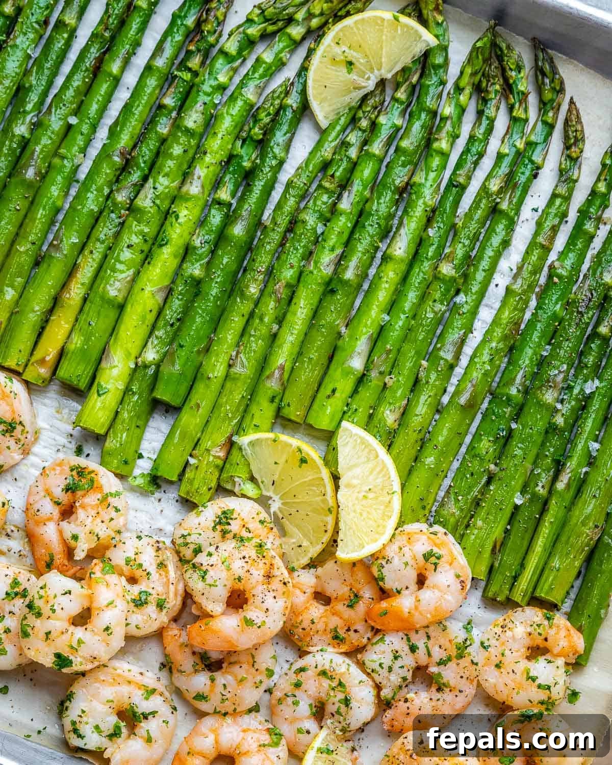 Roasted Garlic Shrimp & Asparagus Sheet Pan Dinner 8 An appetizing angled shot of a sheet pan filled with golden-brown shrimp and tender asparagus, highlighting the vibrant colors and appealing texture.