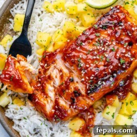 Fire-Kissed Salmon 11 Close-up of crispy BBQ salmon served over rice with mango salsa, showcasing the vibrant colors and appealing textures of the dish.