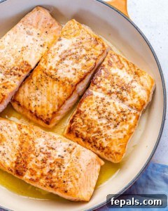 Fire-Kissed Salmon 12 Seared salmon fillets cooking in a pan, showcasing the golden crust.