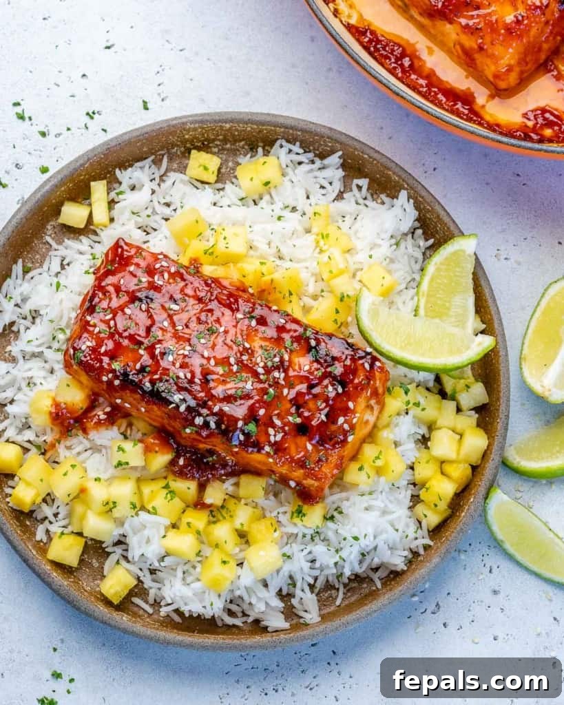 Fire-Kissed Salmon 4 Top view of beautifully pan-seared BBQ salmon fillets served with rice and sweet pineapple chunks, highlighting the vibrant colors and appealing presentation.