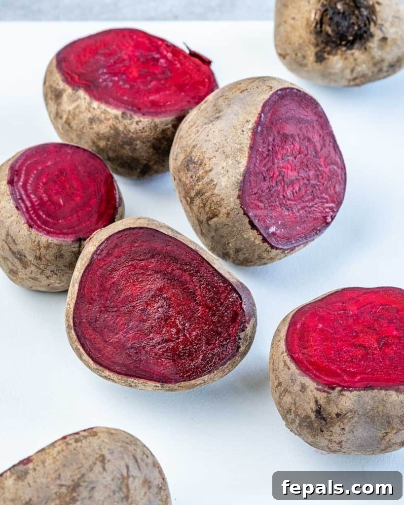 Close-up view of whole beets, expertly trimmed and ready for roasting, showcasing their deep red hue.