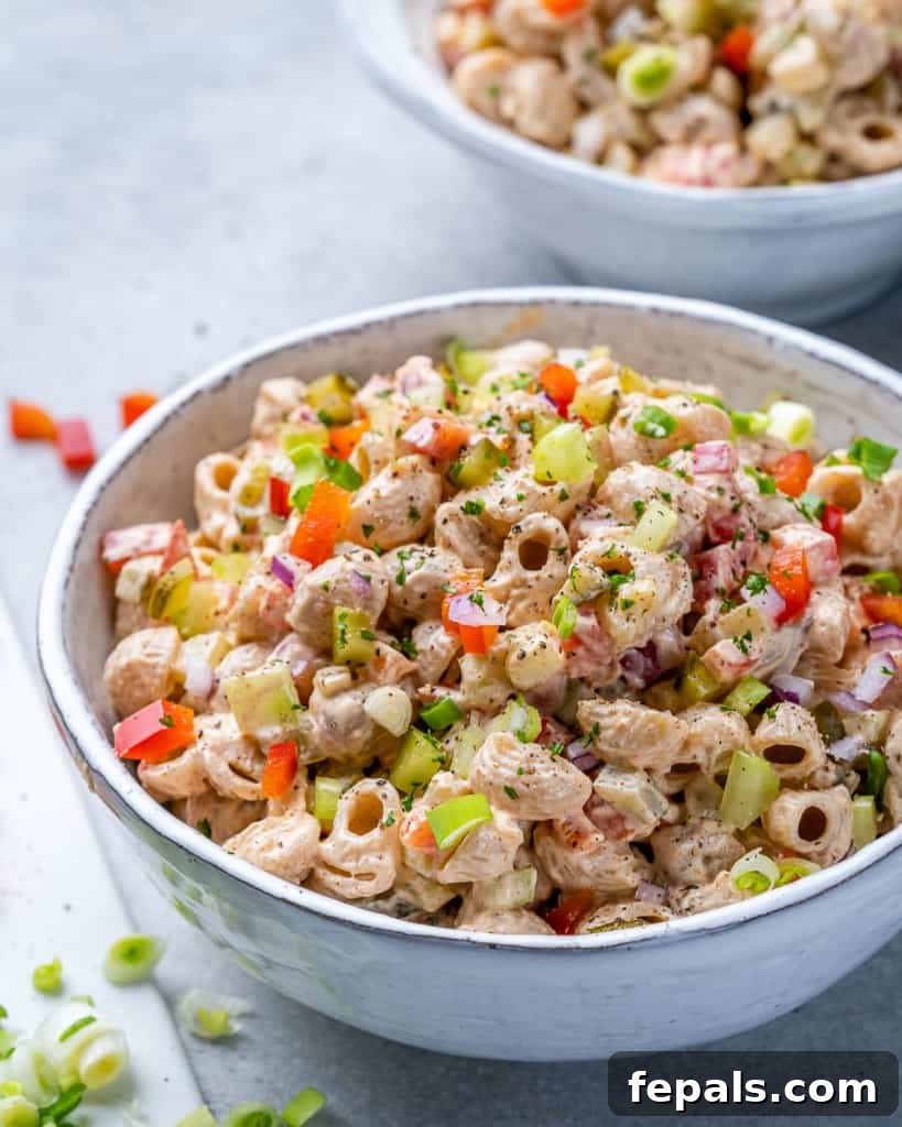 Grandma's Simple Macaroni Salad 8 side shot of a bowl of macaroni salad with a fork, showcasing its creamy texture