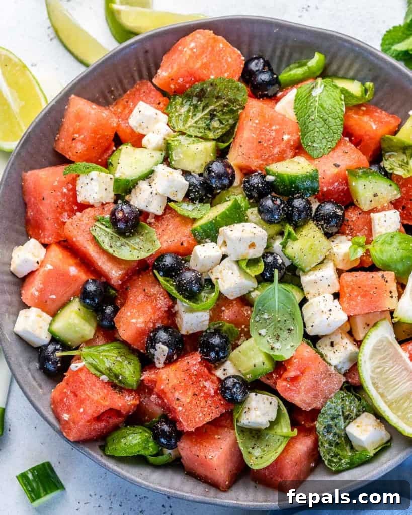 Vibrant Watermelon Feta Salad 7 Overhead shot of the colorful watermelon feta salad in a bowl, with a focus on the vibrant red watermelon and green herbs, suggesting freshness and flavor.
