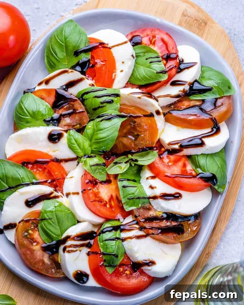 Effortless Caprese Perfection 9 Top view of a freshly prepared Caprese salad, artfully arranged on a white plate, ready to be enjoyed as a refreshing meal.