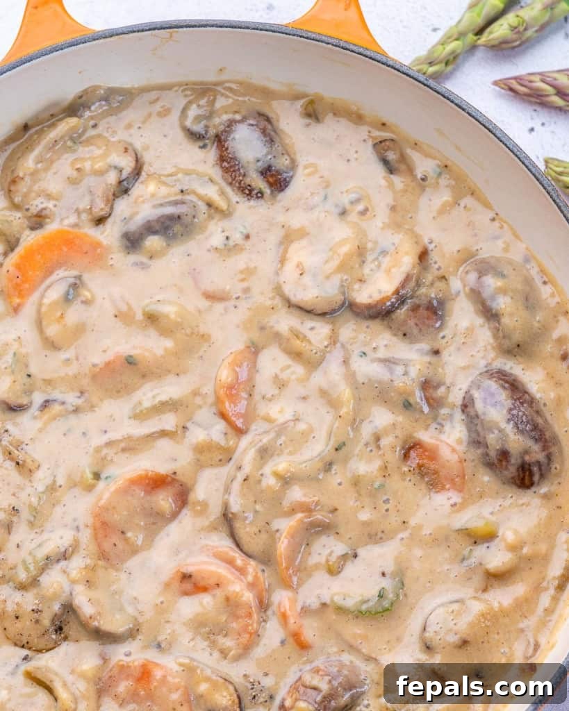 Velvet Chicken Supper 6 Close-up top view of sautéed mushrooms, onions, and other vegetables in a pan, with a whisked milk and flour mixture nearby, ready to be combined for the fricassee sauce.