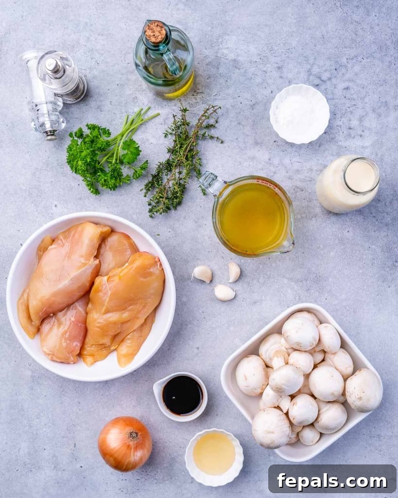 Fresh ingredients laid out on a wooden board, including chicken breasts, mushrooms, herbs, and bottles of olive oil and balsamic vinegar, ready for the skillet.