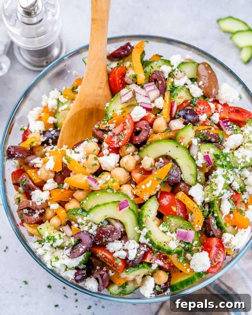 Zesty Greek Garbanzo Medley 3 top view chickpea salad in a bowl with wooden spoon in it