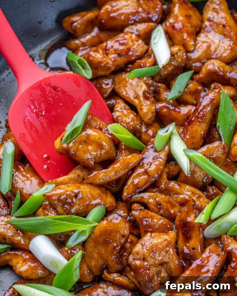 Sticky Garlic Mongolian Chicken 6 chicken and sauce cooked in pan with green onion garnish