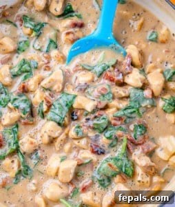 creamy chicken sauce with spinach in a skillet.